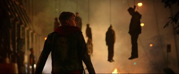 Movie still from “Metallica Through the Never” (2013), directed by Nimród Antal – A man standing in front of a group of people hanging from ropes; Wide shot, Low angle