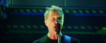 A man is singing into a microphone in a room