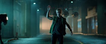 Movie still from “Metallica Through the Never” (2013), directed by Nimród Antal – A man in a green vest waving at the camera; Medium shot, Low angle