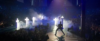 Movie still from “Metallica Through the Never” (2013), directed by Nimród Antal – A man in a black shirt is playing guitar; Extreme Wide shot, High angle