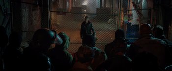 Movie still from “Metallica Through the Never” (2013), directed by Nimród Antal – A group of people standing in front of a chain link fence; Wide shot, Over the shoulder angle