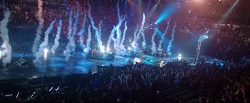 Movie still from “Metallica Through the Never” (2013), directed by Nimród Antal – A crowd of people in a stadium with smoke coming out of them; Extreme Wide shot, High angle