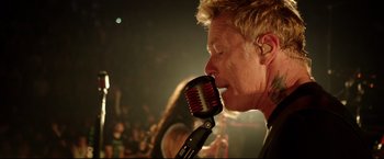 Movie still from “Metallica Through the Never” (2013), directed by Nimród Antal – A man with his mouth open holding a microphone; Close Up shot, Overhead angle