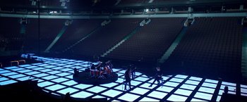 Movie still from “Metallica Through the Never” (2013), directed by Nimród Antal – A group of people sitting in a room with lights on; Extreme Wide shot, High angle