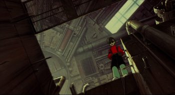 Movie still from “Metropolis” (2001), directed by Rintarô – An animated scene of a man standing in front of a screen; Wide shot, Low angle