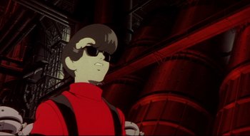 Movie still from “Metropolis” (2001), directed by Rintarô – A man wearing a red shirt and sunglasses in front of a red wall; Medium shot, Low angle