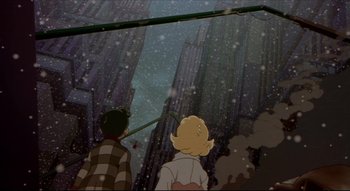 Movie still from “Metropolis” (2001), directed by Rintarô – A couple of people standing next to each other in front of a tall building; Extreme Wide shot, Low angle