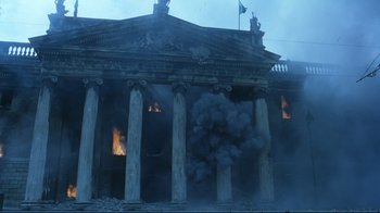 Movie still from “Michael Collins” (1996), directed by Neil Jordan – A building that has been set ablaze by a fire; Extreme Wide shot, Low angle