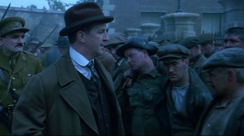 Movie still from “Michael Collins” (1996), directed by Neil Jordan – A group of men standing next to each other; Medium shot, Over the shoulder angle