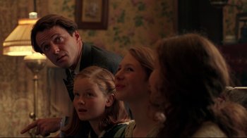 Movie still from “Michael Collins” (1996), directed by Neil Jordan – A group of people sitting in a room together; Medium shot, Over the shoulder angle