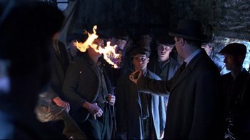 Movie still from “Michael Collins” (1996), directed by Neil Jordan – A group of men standing next to each other; Medium shot, Over the shoulder angle
