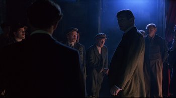 Movie still from “Michael Collins” (1996), directed by Neil Jordan – A group of men standing in the dark; Medium shot, Over the shoulder angle