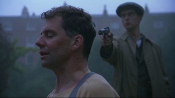 Movie still from “Michael Collins” (1996), directed by Neil Jordan – A man holding a camera in front of another man; Close Up shot, Over the shoulder angle
