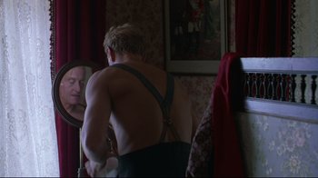 Movie still from “Michael Collins” (1996), directed by Neil Jordan – A man in a bathroom looking in a mirror; Medium shot, Over the shoulder angle