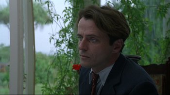 Movie still from “Michael Collins” (1996), directed by Neil Jordan – A person wearing a suit and tie; Close Up shot, Over the shoulder angle