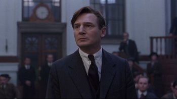 Movie still from “Michael Collins” (1996), directed by Neil Jordan – A man wearing a suit and tie in front of a crowd; Close Up shot, Low angle