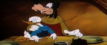 Movie still from “Mickey and the Beanstalk” (1947), directed by Hamilton Luske – A goofy character sitting at a table with another goofy character; Medium shot, Over the shoulder angle