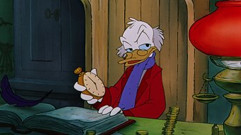 Movie still from “Mickey's Christmas Carol” (1983), directed by Burny Mattinson – A cartoon of scrooge mcduck sitting at a table; Medium shot, High angle