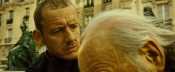 Movie still from “Micmacs” (2009), directed by Jean-Pierre Jeunet – A person looking at another person; Close Up shot, Over the shoulder angle