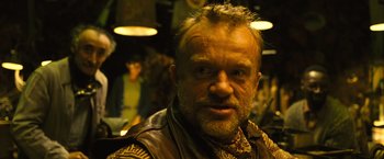 Movie still from “Micmacs” (2009), directed by Jean-Pierre Jeunet – A person wearing a leather vest; Close Up shot, Over the shoulder angle