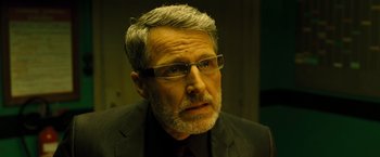 Movie still from “Micmacs” (2009), directed by Jean-Pierre Jeunet – An older man wearing a black suit and glasses; Close Up shot, Low angle