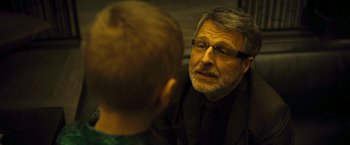 Movie still from “Micmacs” (2009), directed by Jean-Pierre Jeunet – An older man and a young boy are talking to each other; Close Up shot, Over the shoulder angle
