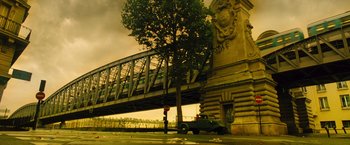 Movie still from “Micmacs” (2009), directed by Jean-Pierre Jeunet – An old truck parked on the side of the road under a bridge; Extreme Wide shot, Low angle