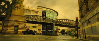 Movie still from “Micmacs” (2009), directed by Jean-Pierre Jeunet – A building that has a bridge going over it; Extreme Wide shot, Low angle