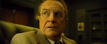 Movie still from “Micmacs” (2009), directed by Jean-Pierre Jeunet – An older man wearing glasses and a suit; Close Up shot, Low angle