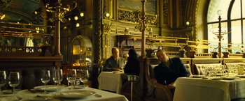 Movie still from “Micmacs” (2009), directed by Jean-Pierre Jeunet – A group of people sitting around a table in a restaurant; Wide shot, Low angle