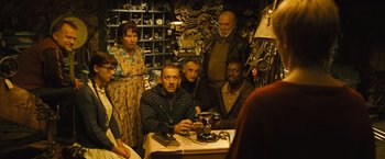 Movie still from “Micmacs” (2009), directed by Jean-Pierre Jeunet – A group of people sitting around a table; Medium shot, High angle