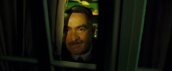 Movie still from “Micmacs” (2009), directed by Jean-Pierre Jeunet – A person looking through a window; Close Up shot, Low angle