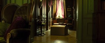 Movie still from “Micmacs” (2009), directed by Jean-Pierre Jeunet – A living room filled with furniture next to a large window; Wide shot, High angle