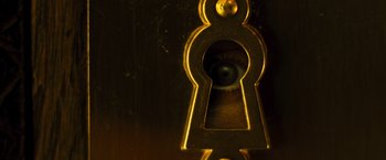 Movie still from “Micmacs” (2009), directed by Jean-Pierre Jeunet – An open keyhole with an eye in it; Extreme Close Up shot, Overhead angle