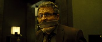 Movie still from “Micmacs” (2009), directed by Jean-Pierre Jeunet – A man with a duct tape over his mouth; Close Up shot, Low angle