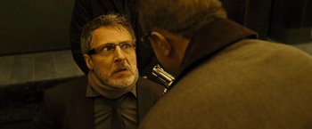 Movie still from “Micmacs” (2009), directed by Jean-Pierre Jeunet – A man in a suit and tie looking at another man in a suit and tie; Close Up shot, Over the shoulder angle