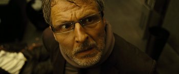 Movie still from “Micmacs” (2009), directed by Jean-Pierre Jeunet – An older man wearing glasses and a jacket; Close Up shot, Low angle
