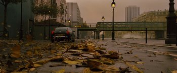 Movie still from “Micmacs” (2009), directed by Jean-Pierre Jeunet – A car is parked on the side of the road; Extreme Wide shot, Low angle