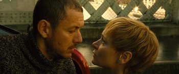 Movie still from “Micmacs” (2009), directed by Jean-Pierre Jeunet – A man and a woman face to face with one holding an object in his mouth; Close Up shot, Low angle