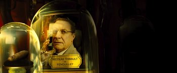 Movie still from “Micmacs” (2009), directed by Jean-Pierre Jeunet – A glass dome with a picture of a man inside of it; Close Up shot, Low angle