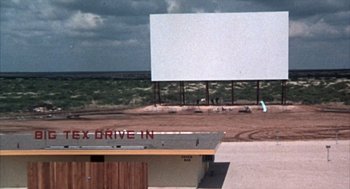Movie still from “Midnight Cowboy” (1969), directed by John Schlesinger – An empty drive - in movie screen on the side of the road; Extreme Wide shot, Low angle