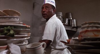 Movie still from “Midnight Cowboy” (1969), directed by John Schlesinger – A man wearing a chef's hat in a restaurant kitchen; Close Up shot, Low angle
