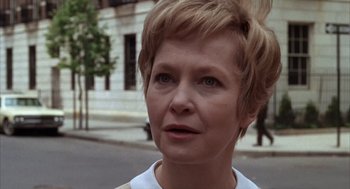 Movie still from “Midnight Cowboy” (1969), directed by John Schlesinger – A person with short hair on a city street; Close Up shot, Over the shoulder angle