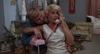 Movie still from “Midnight Cowboy” (1969), directed by John Schlesinger – A man and a woman on a pink phone; Medium shot, Low angle