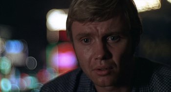 Movie still from “Midnight Cowboy” (1969), directed by John Schlesinger – A person wearing a plaid shirt; Close Up shot, Over the shoulder angle