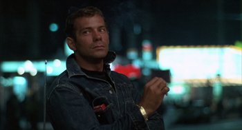 Movie still from “Midnight Cowboy” (1969), directed by John Schlesinger – A man smoking a cigarette while holding a cell phone in his hand; Close Up shot, Low angle