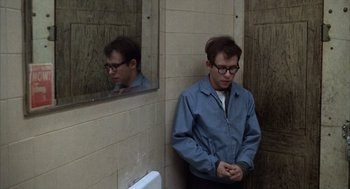 Movie still from “Midnight Cowboy” (1969), directed by John Schlesinger – A man standing in front of a mirror in a bathroom; Medium shot, High angle