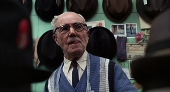 Movie still from “Midnight Cowboy” (1969), directed by John Schlesinger – An older man wearing a blue sweater and a tie; Close Up shot, Low angle