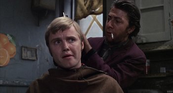 Movie still from “Midnight Cowboy” (1969), directed by John Schlesinger – A man getting his hair combed by another man; Close Up shot, Over the shoulder angle