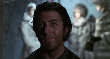 Movie still from “Midnight Cowboy” (1969), directed by John Schlesinger – A man's face in front of a group of people; Close Up shot, Low angle